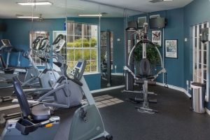 Fitness center with multiple workout machines and mirrored wall